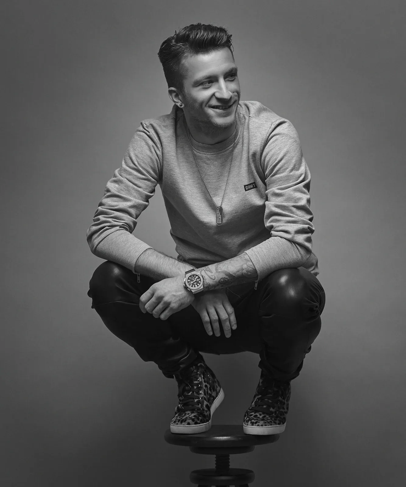 Marco Reus hockt auf einem Hocker, Schwarz-Weiß-Porträt